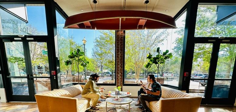 Lounge area with natural light and a canoe hanging from the ceiling at 100 Main Street SW, Gainesville (GA).