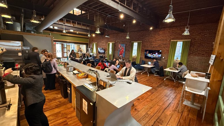 Spacious communal coworking area at 111 W Lewis St, Greensboro (Georgia) with brick walls and exposed beams.