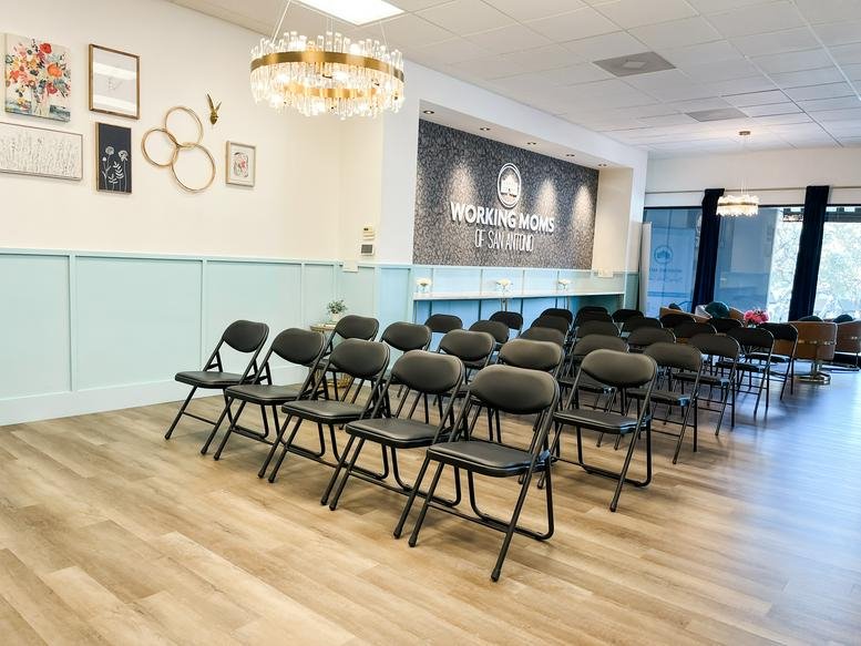 Spacious communal event area at 11854 Wurzbach Road with rows of black folding chairs.