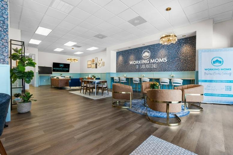 Bright coworking area at 11854 Wurzbach Road with a branded feature wall and lounge seating.