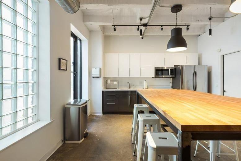 Bright kitchen area at 1212 North Ashland Avenue featuring a long wooden table and stainless steel appliances.