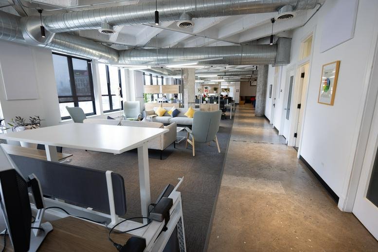 Spacious interior view of 1212 North Ashland Avenue featuring open ceilings and a polished concrete hallway.