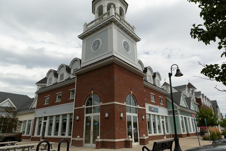 Exterior view of the brick building with a prominent clock tower at 132 Chief Justice Cushing Highway.