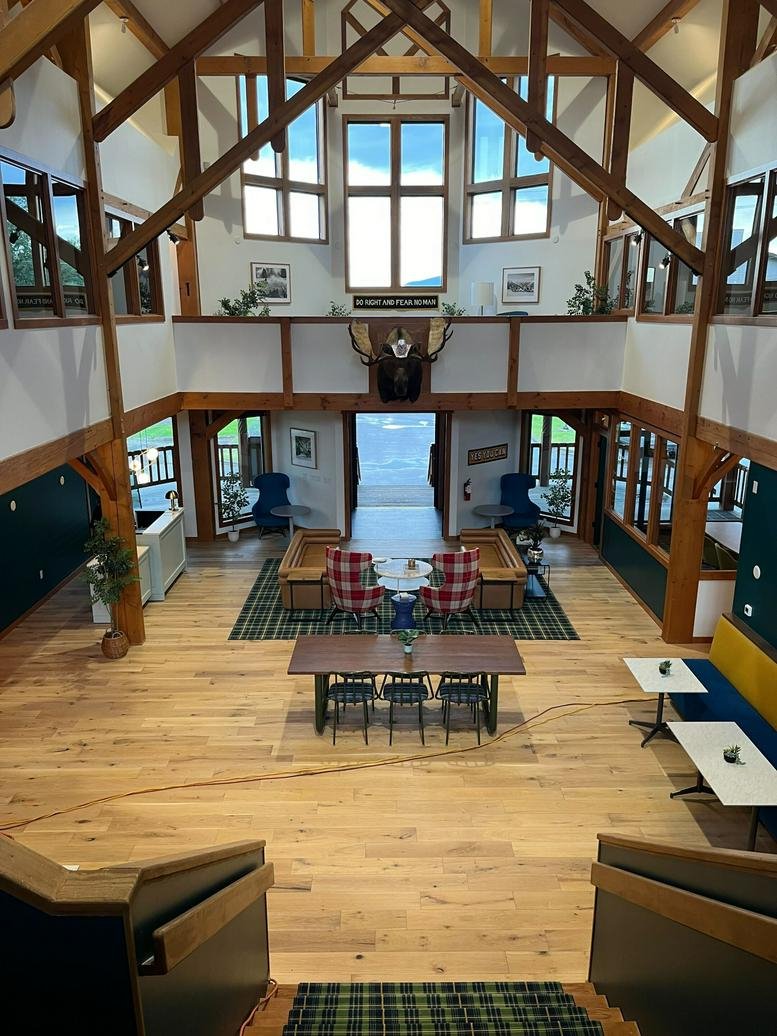 Spacious two-story communal lounge at 1716 W Babcock Street featuring timber beams and a mounted moose head.