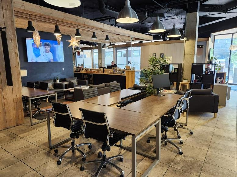 Wide-angle view of a modern lobby with seating areas and a television.