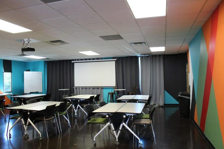 Spacious training room at 221 East Indianola Avenue with colourful mural and projector screen.