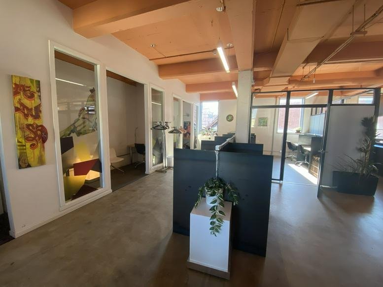Spacious open-plan workspace at 2700 Rue Angus with timber ceilings and modern glass-walled offices.