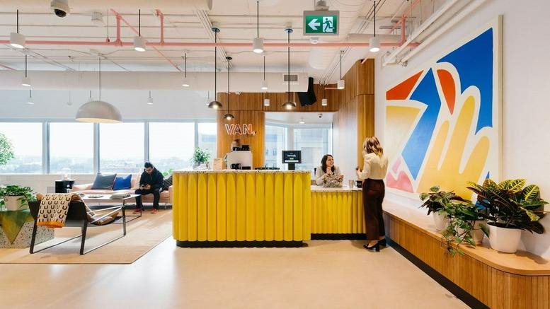 Bright reception area at 333 Seymour Street, Vancouver, British Columbia with a yellow desk and colorful wall art.