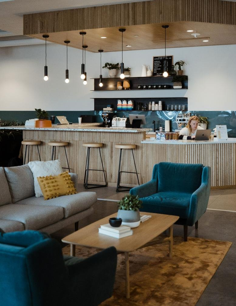 Modern café and breakout space at 3400 North Central Expressway No. 110 with wooden bar and velvet seating.