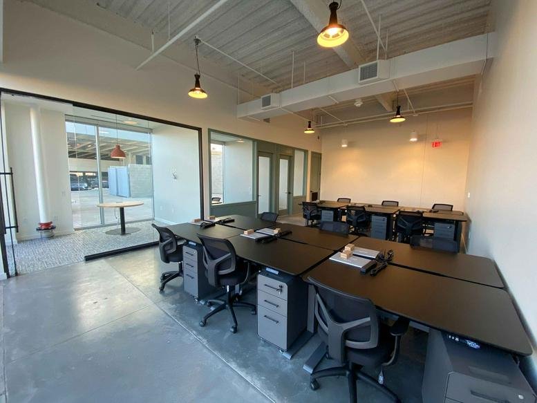 Interior of 3400 North Central Expressway No. 110 showing a bright open-plan workspace with sleek black desks.