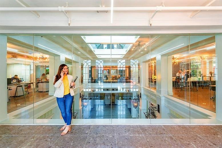 Upper-level landing overlooking a bright atrium with glass partitions.