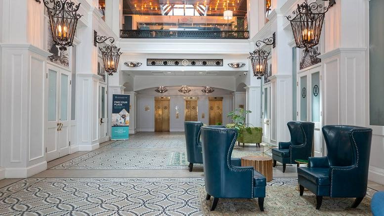 Grand lobby entrance at 37 N. Orange Avenue showing teal wingback chairs and ornate hanging lanterns.