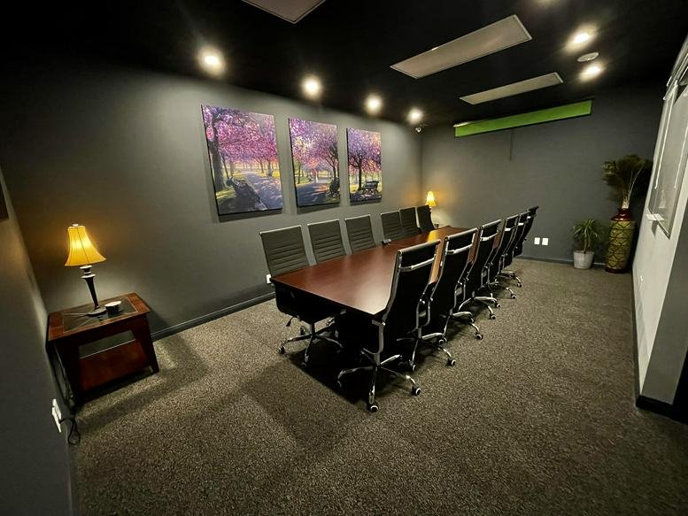 Meeting room at 3800 Barham Boulevard No. 105 with a long wood table and dark grey walls.