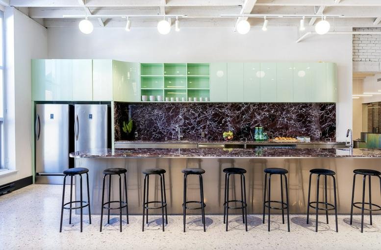 Spacious communal kitchen and lounge at 4012 Avenue Wellington featuring a long marble island and green cabinets.