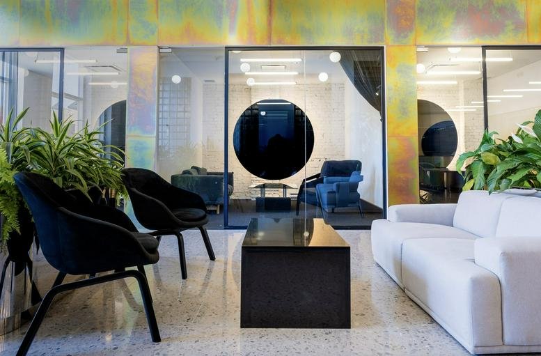 Bright lobby and lounge area at 4012 Avenue Wellington with colorful wall art and plush seating.