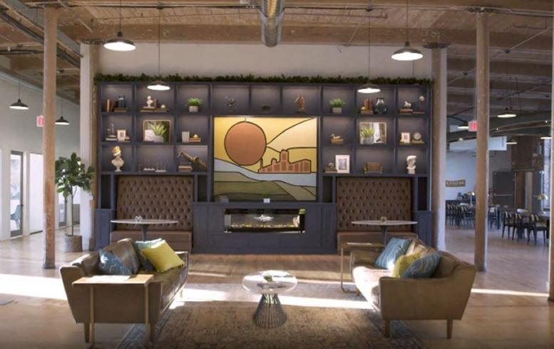 Spacious lounge area featuring a large feature wall, modern sofas, and warm industrial lighting.