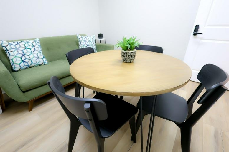 Cozy breakout area featuring a green sofa and a round wooden meeting table.