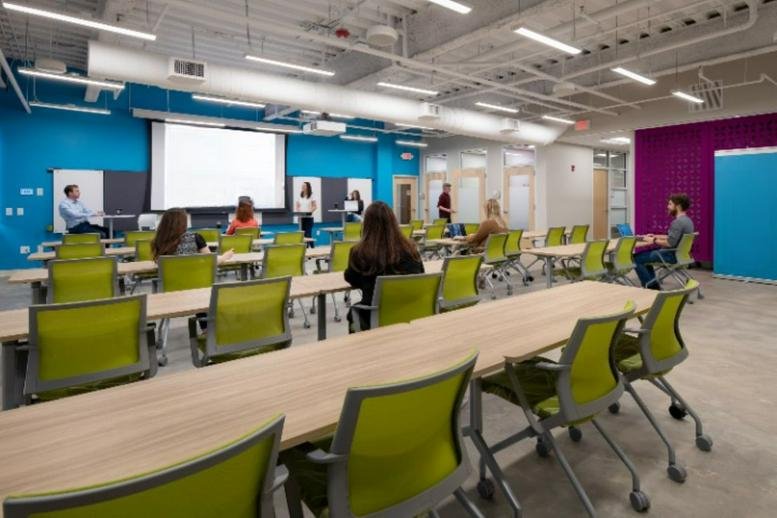 Spacious presentation room at 57 Union Street South with tiered seating and a large projector screen.