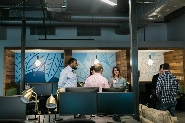 Spacious communal lounge at 5830 Granite Parkway No. 100 with people collaborating near workstations.
