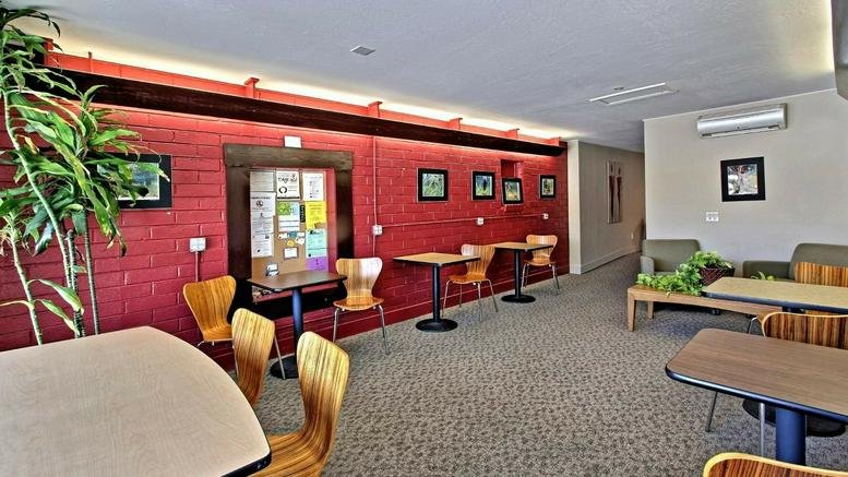 Spacious communal lounge at 6265 Highway 9, Felton, California with a red brick wall and wooden furniture.