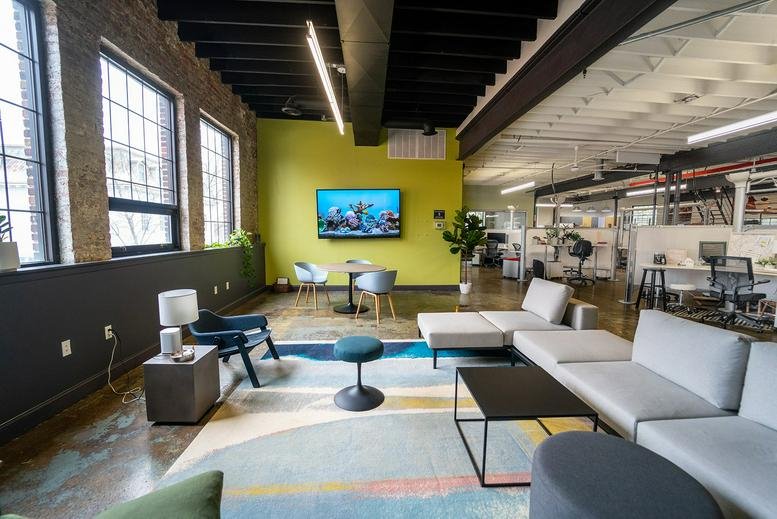Spacious communal lounge at 8 North Front Street, Kingston (NY), New York featuring a lime green wall and large windows.