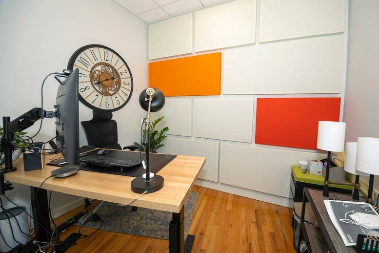 Private office at 805 Greenwood Street, Dempster, Evanston, Illinois featuring acoustic wall panels and a large clock.