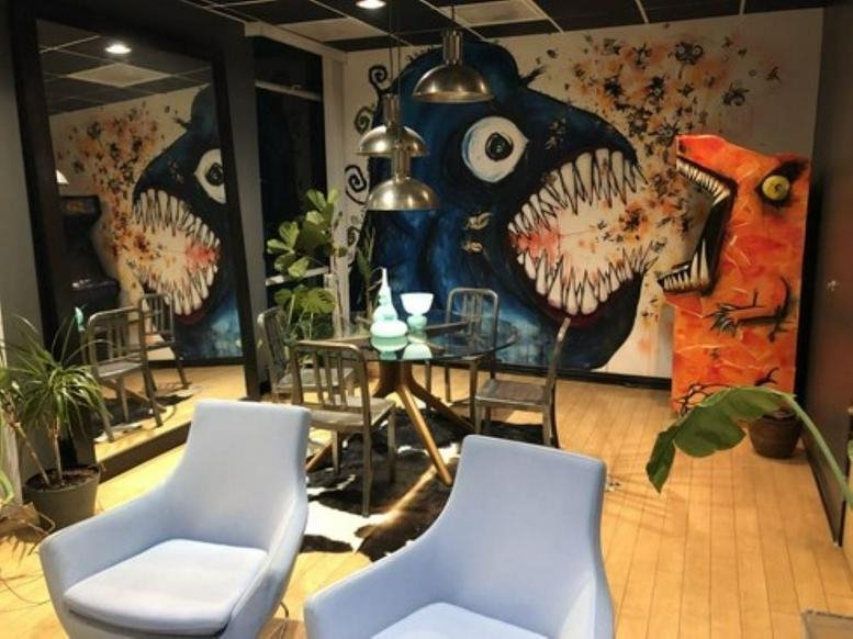 Colorful communal lounge at 8730 Wilshire Boulevard Suite 350 featuring vibrant wall murals and modern armchairs.