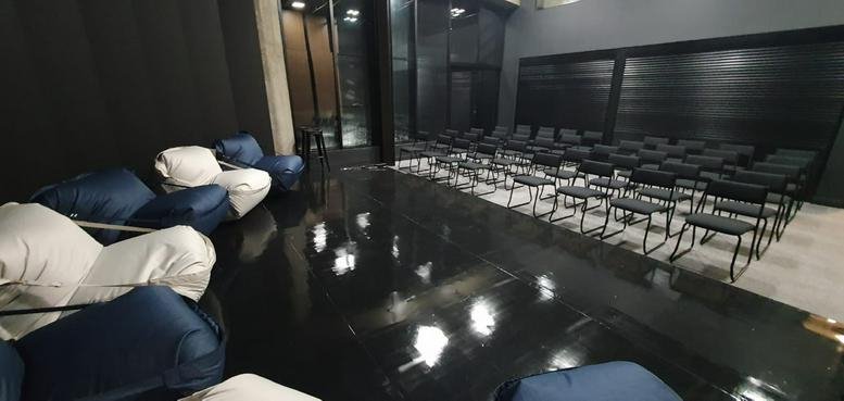 Ample event space at Edifício Capitania with rows of chairs and comfortable beanbag seating.