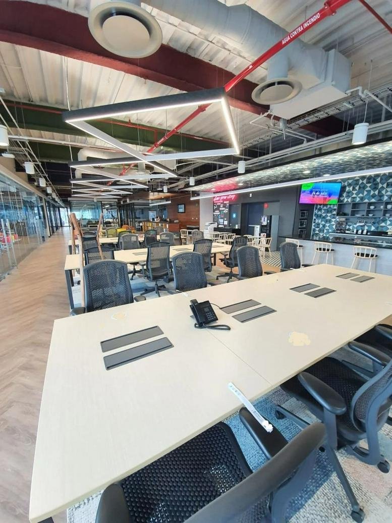 Modern coworking space with wood-slat ceilings and geometric lighting fixtures.
