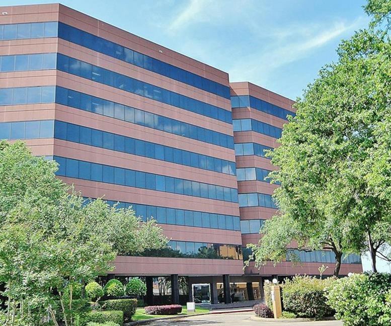 Exterior view of the multi-story brick and glass office building at Southwest Freeway, Houston, Texas.