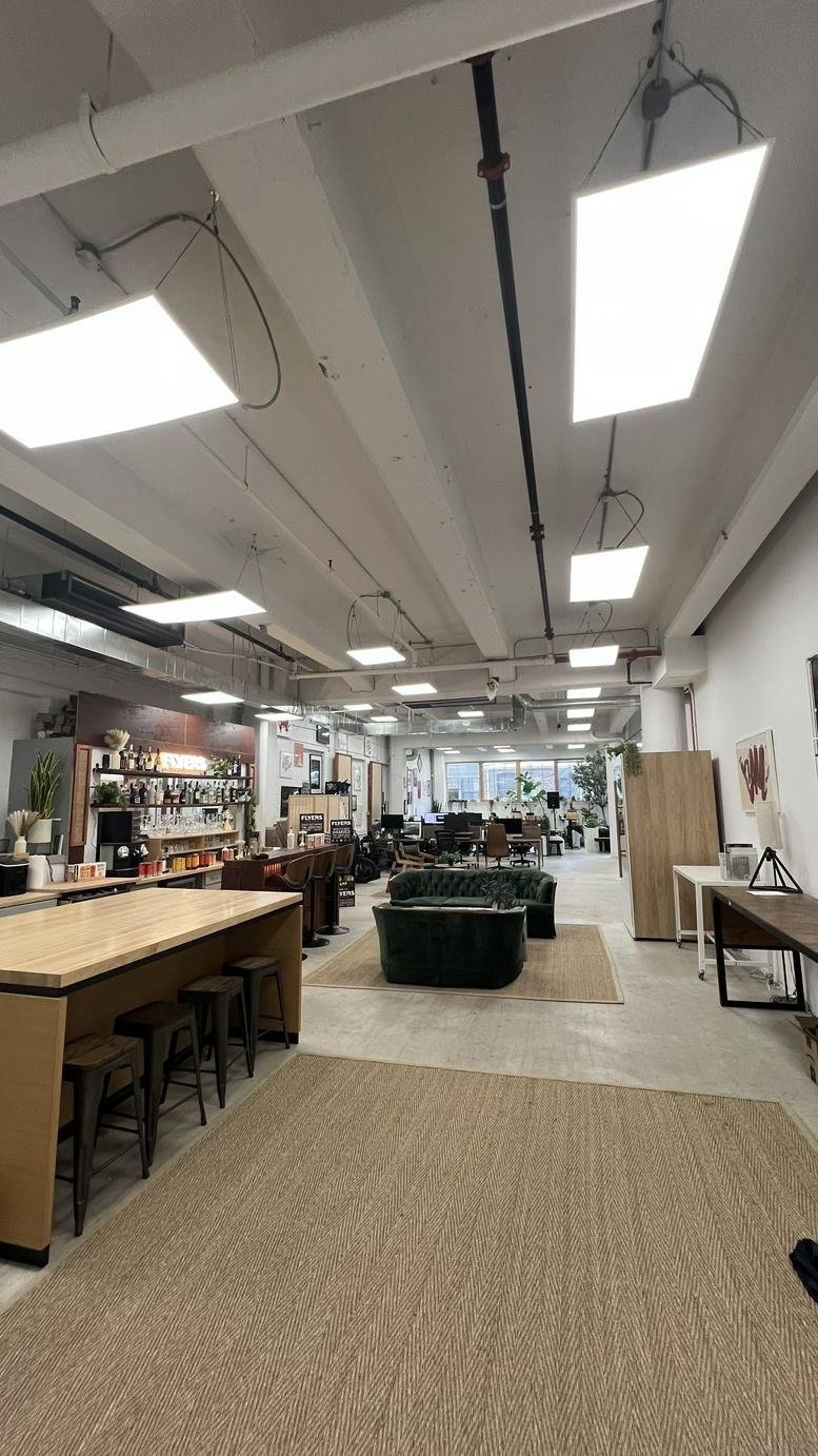 Spacious communal area at Williamsburg Office, Brooklyn with high ceilings, wood accents, and modern lighting.
