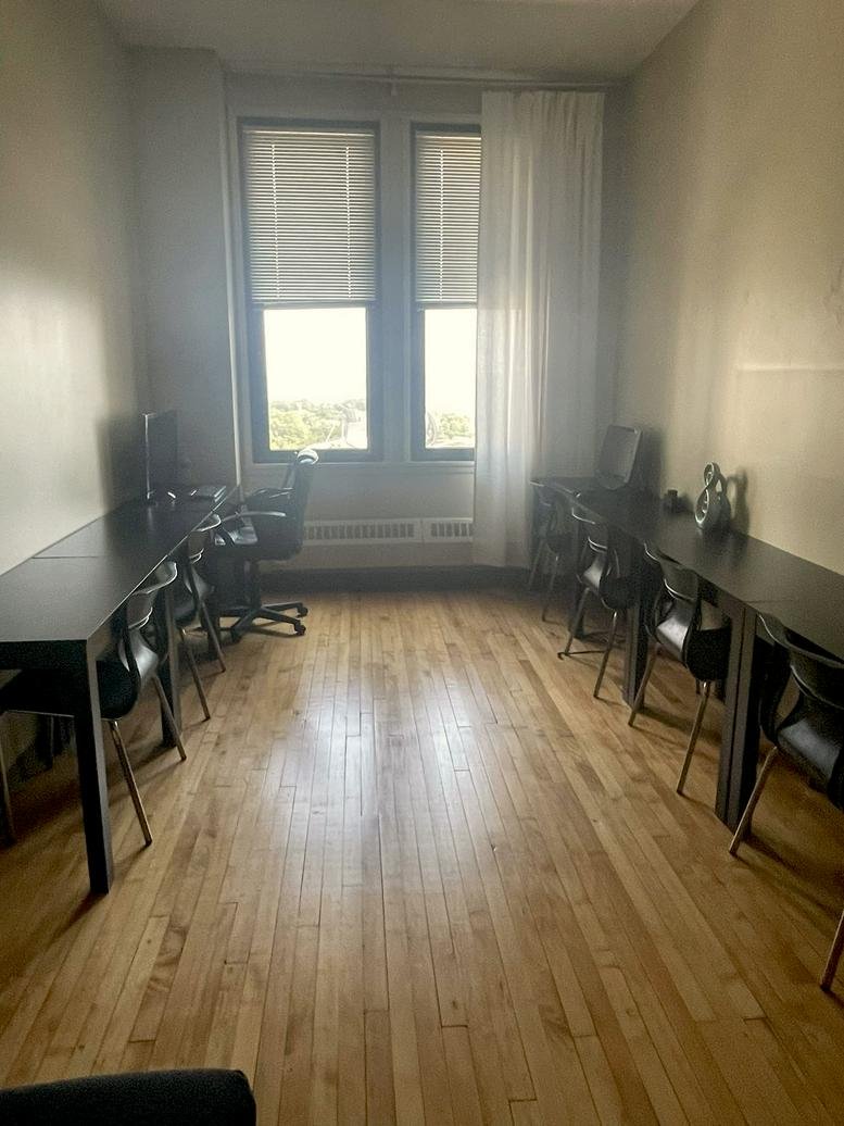 Long open-plan workspace at 111 North Wabash Avenue with dark desks and hardwood floors.