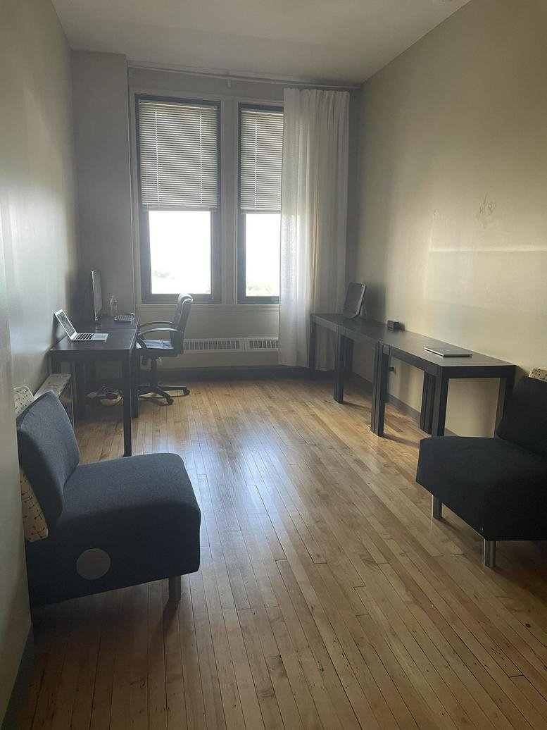Spacious co-working room at 111 North Wabash Avenue with multiple desks and dual-tone lounge chairs.