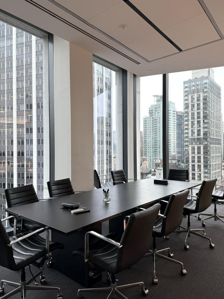 Conference room at 1245 Broadway, 18th Floor, featuring a long black table and floor-to-ceiling city views.