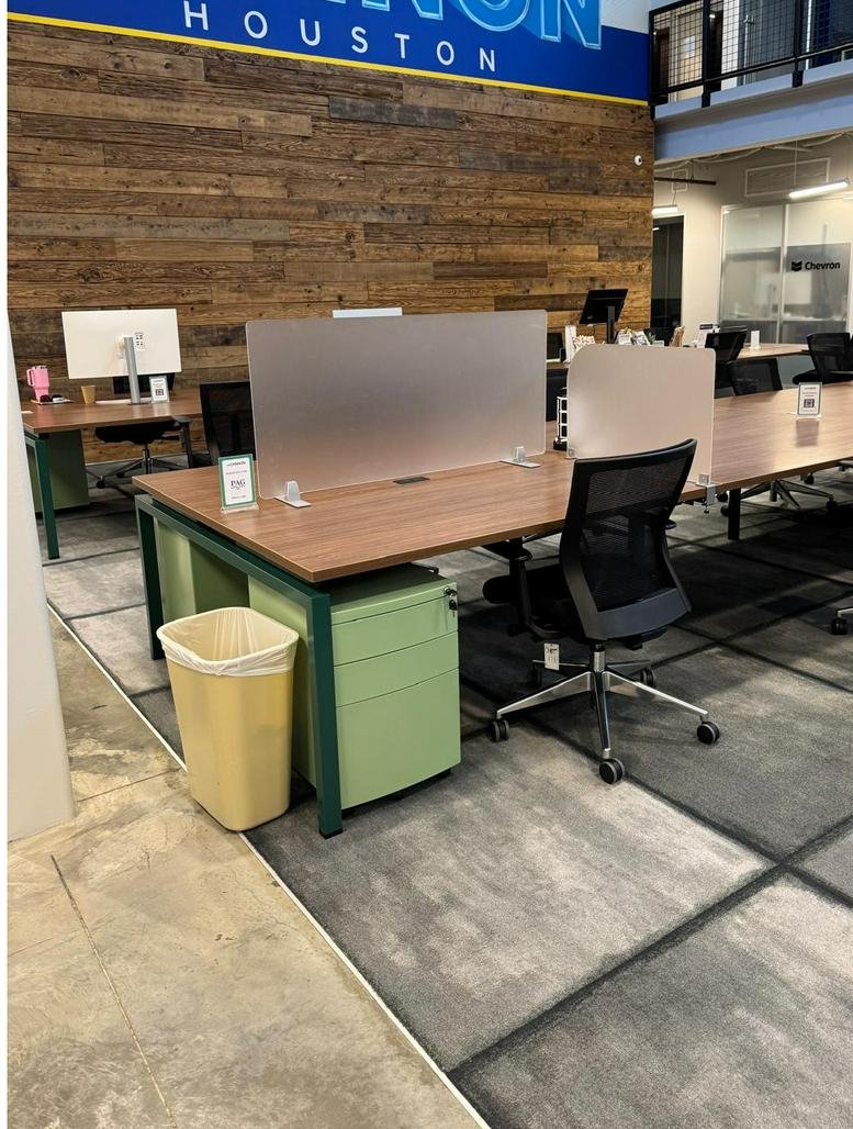 Open-plan office at 1334 Brittmoore Road with wooden feature walls, modern desks, and green storage units.