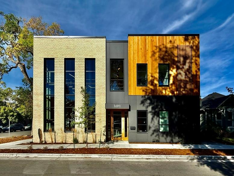 Modern multi-textured exterior of the office at 1691 South Pearl Street under a bright blue sky.