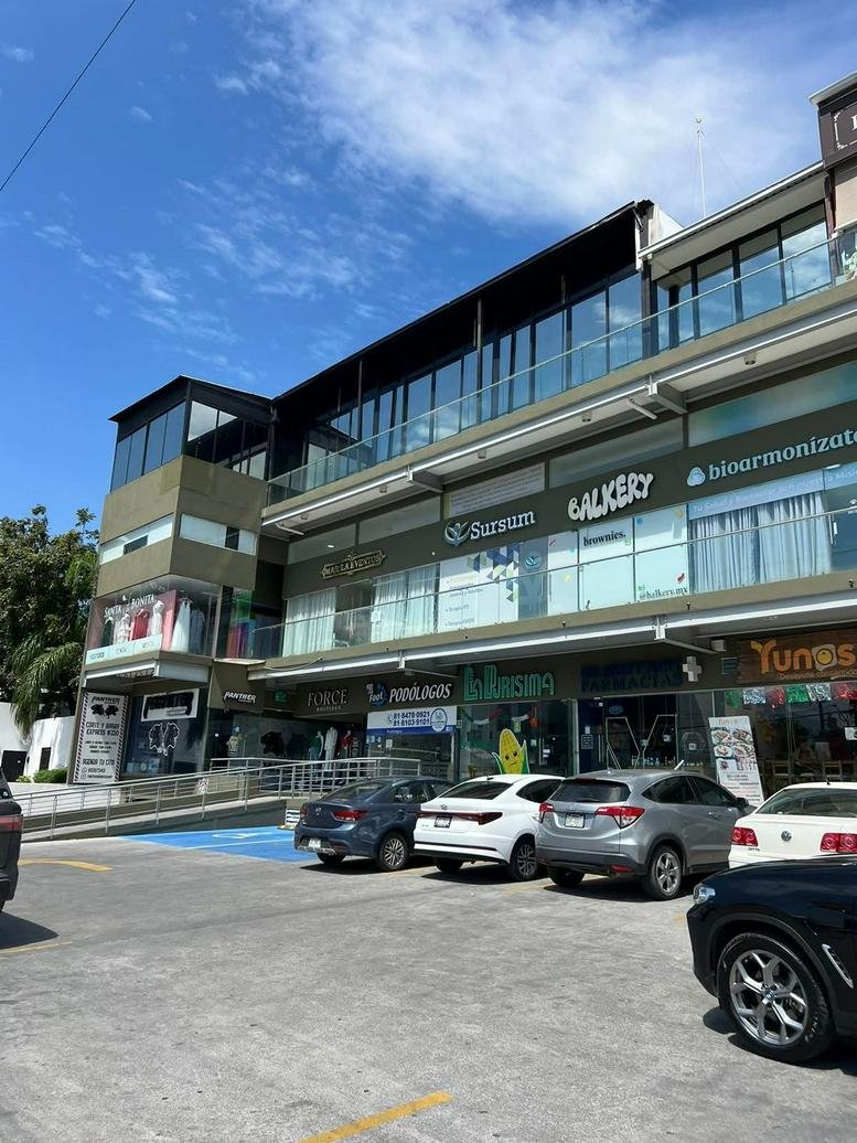 Exterior facade of the multi-level Ocampo Business Center building with ground floor retail and parking.