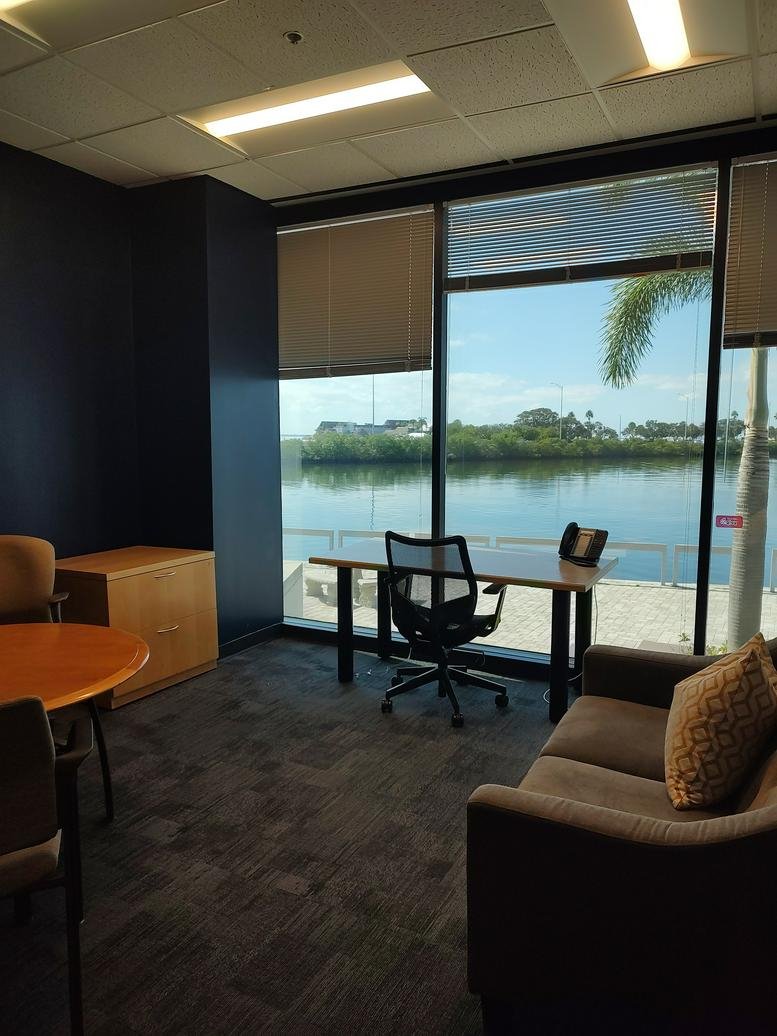 Spacious private office at 3030 N. Rocky Point Dr with floor-to-ceiling windows overlooking a scenic waterway.