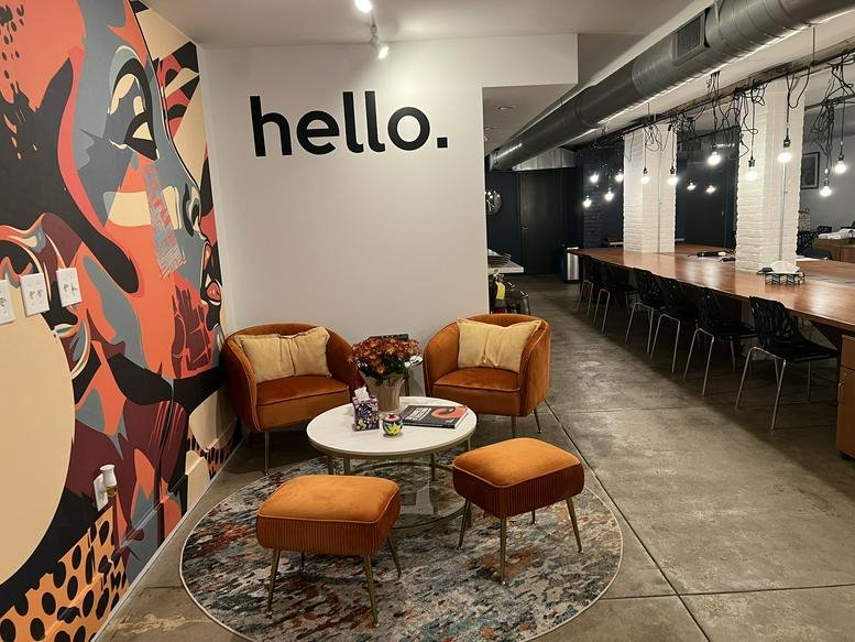 Lounge area at Just Strategies Hub, Mount Airy, Philadelphia featuring orange velvet chairs and a colorful mural.