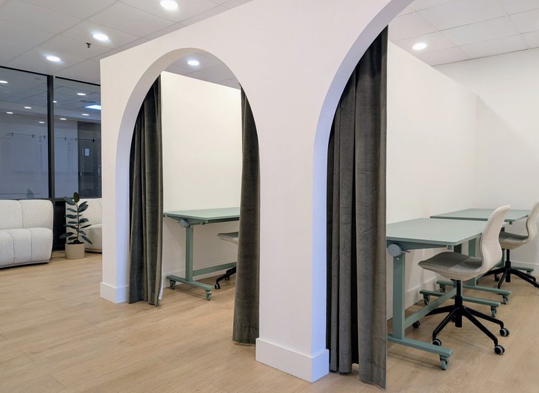 Private arched coworking booths with desks and privacy curtains at Galaxy Mall.