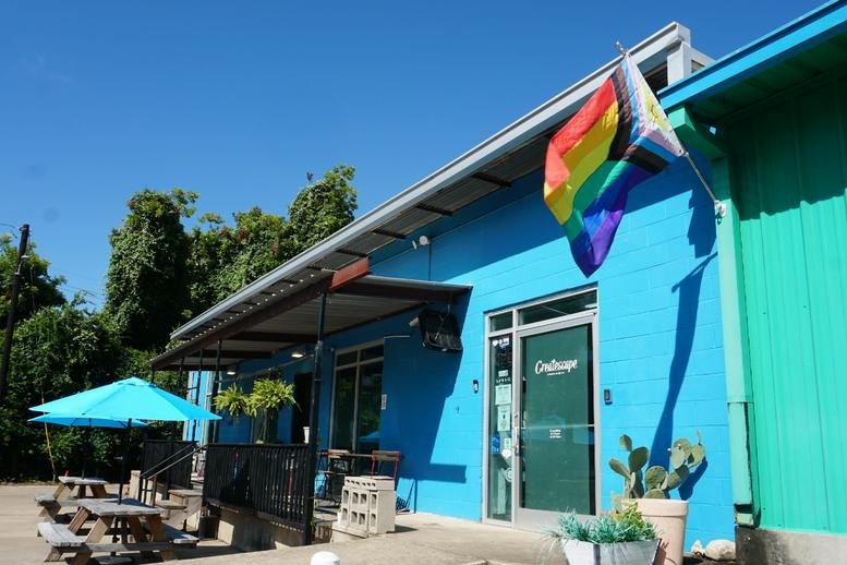 Exterior view of the blue-painted building at 701, Tillery Street No. 12 with a rainbow flag.