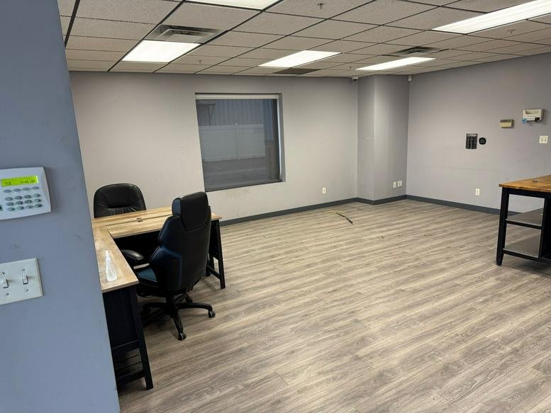 Spacious interior office at 983 East 73rd Avenue, Unit A, Denver, Colorado with wood-look flooring and L-shaped desk.