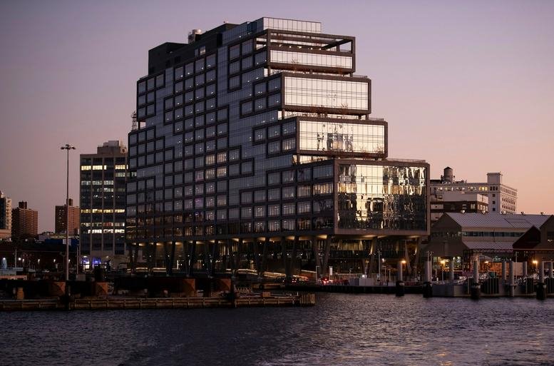 Exterior sunset view of the tiered glass facade at Dock 72, 63 Flushing Avenue in the Brooklyn Navy Yard.
