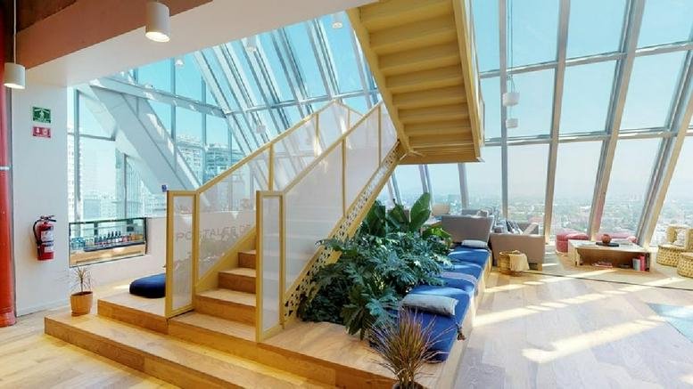 Spacious communal lounge at Lago Alberto 375 with a wooden staircase and large floor-to-ceiling windows.