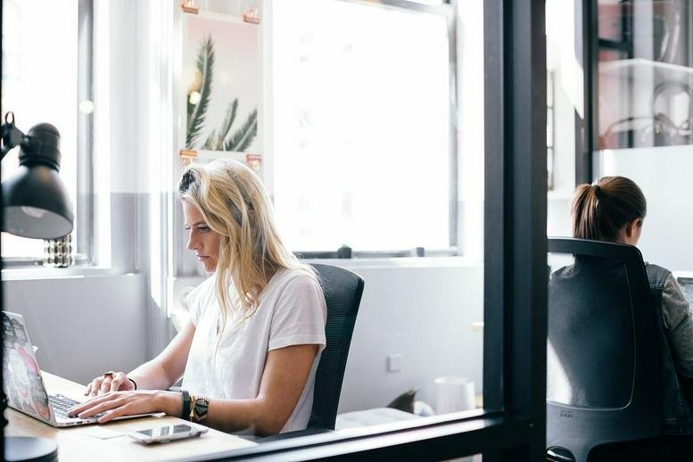 A modern workspace at The Circa Building, 1615 Platte Street featuring natural light and glass partitions.