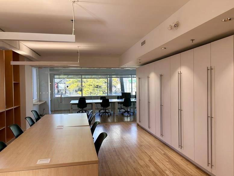 Spacious open-plan workspace at Suite 200, 485 Queen Street West with long wooden tables and natural light.