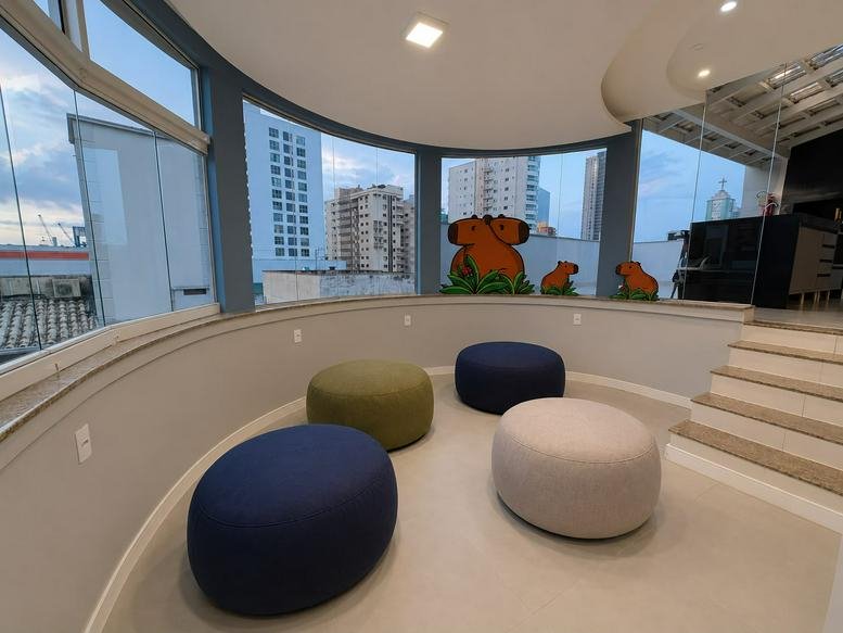 Circular seating nook with colorful ottomans and views of the surrounding city.