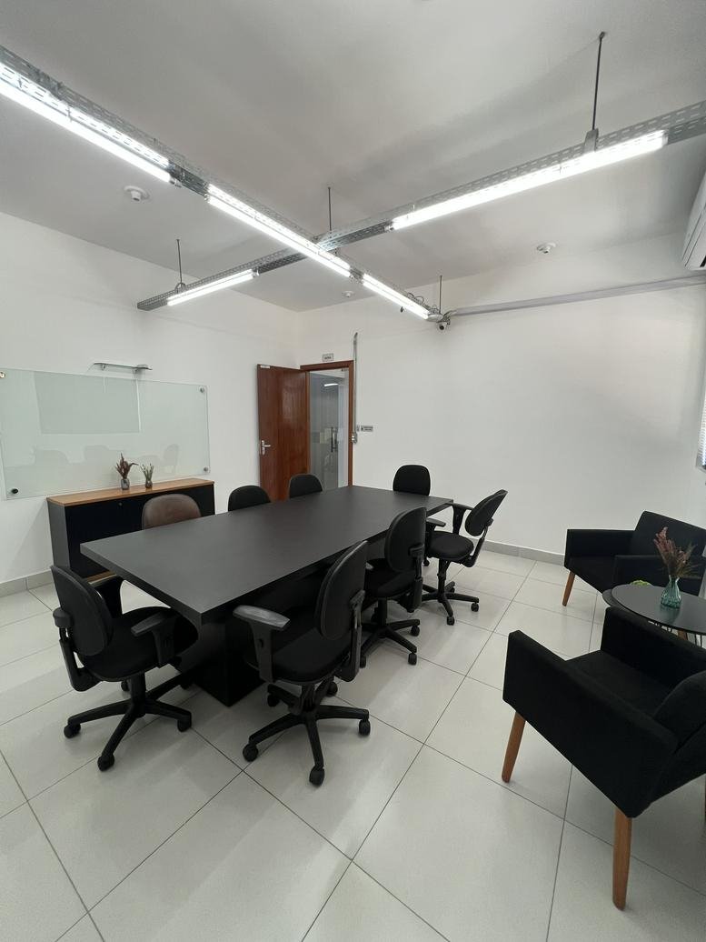 Meeting room at Rua Inconfidência, 140 with a large black conference table and modern black chairs.