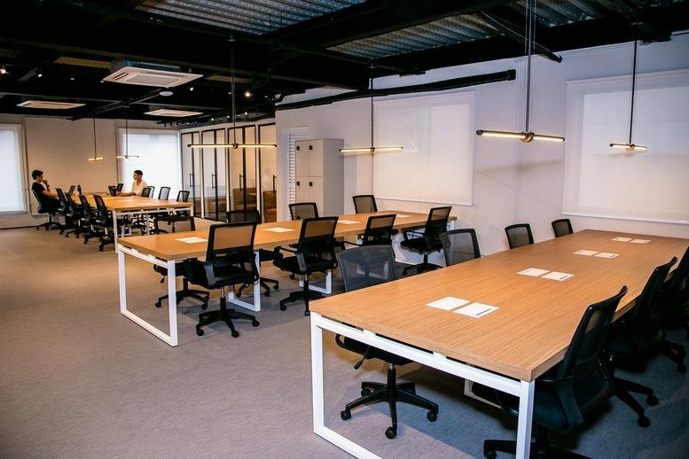 Spacious open-plan workspace at Rua Matias Aires,Número 431 featuring multiple long wooden desks.