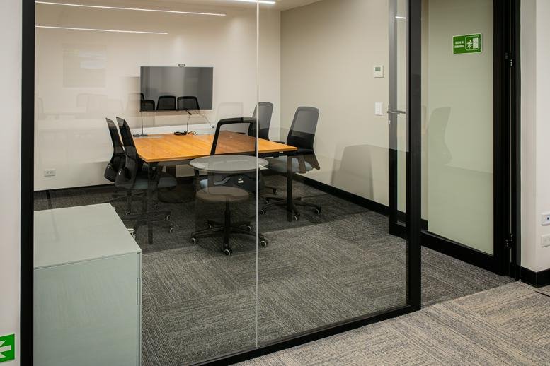 Meeting room with a wooden table and wall-mounted screen at Ruta Nacional Treciaria 310, MULTIPARK.